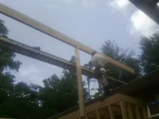 Carpenter setting a ridge beam over a new addition frame — Ice Dam Removal by Roofing Brothers in Rappahannock Academy