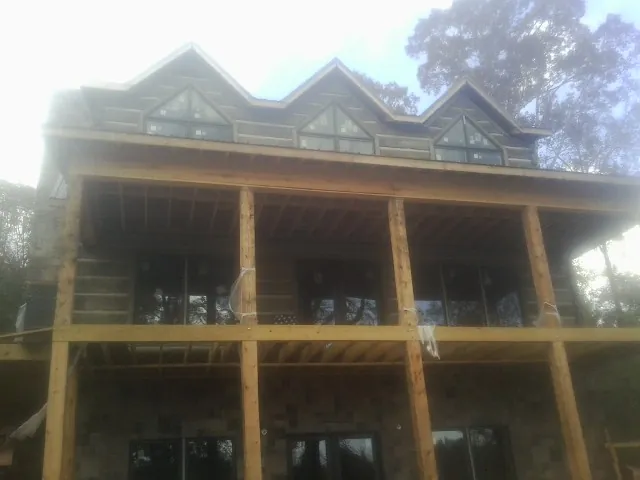 Dormers and porch framing on a large log home under construction in Rappahannock Academy