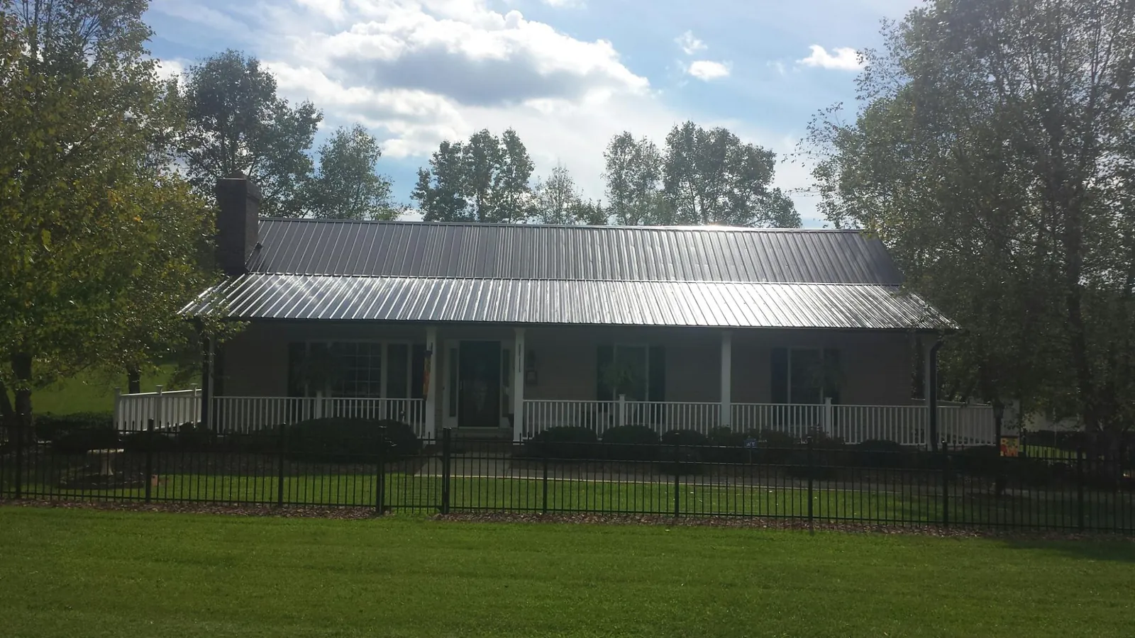 Gray metal roof on a brick ranch with a full width front porch — Gutter Guard Installation work by our crew in Rappahannock Academy