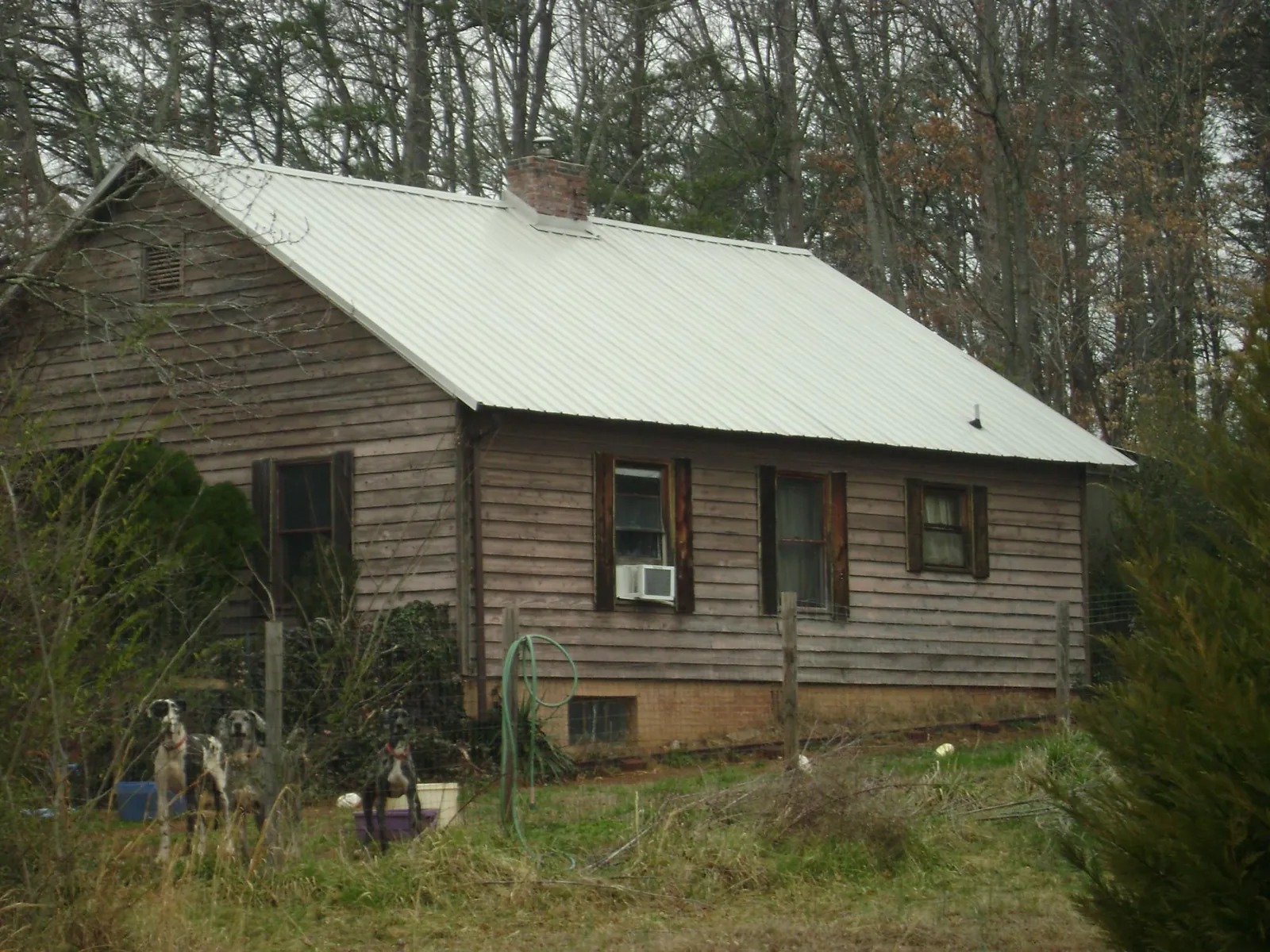 White metal roof on an old wood sided farmhouse, from a Metal Roof Installation job in Rappahannock Academy